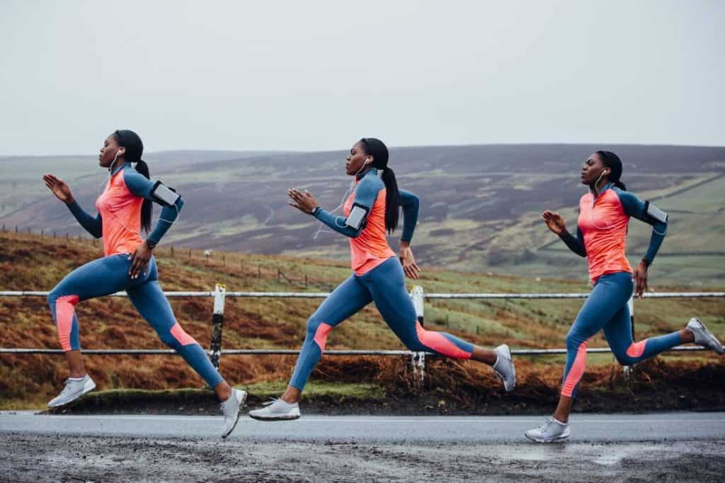 Women running with knee braces during a race on a rural road.