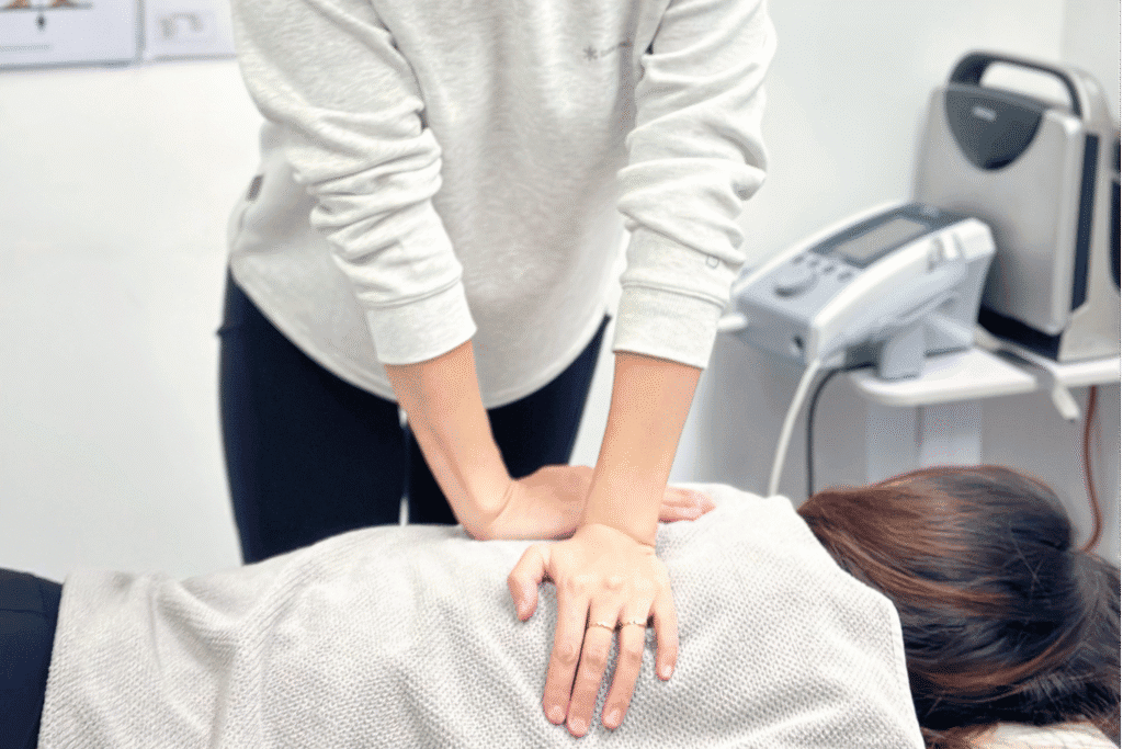 Physiotherapist performing manual therapy techniques on a patient in a clinical setting.