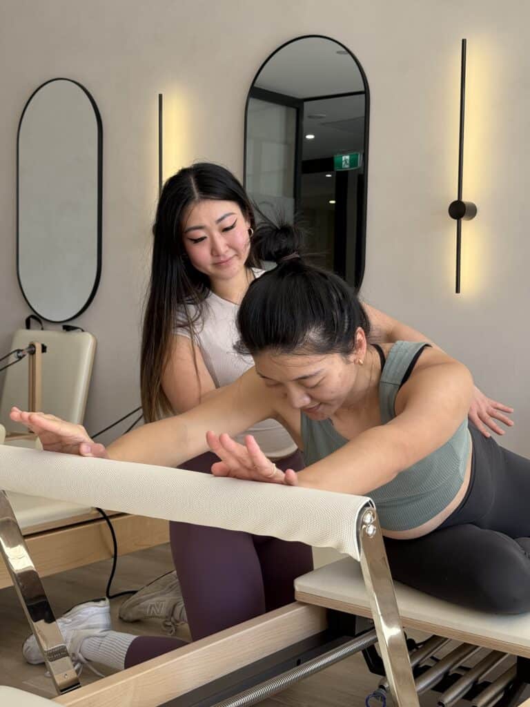 Therapist guiding Pilates exercise