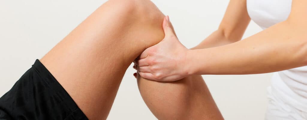 Physiotherapist performing manual therapy on a patient's knee for pain relief.