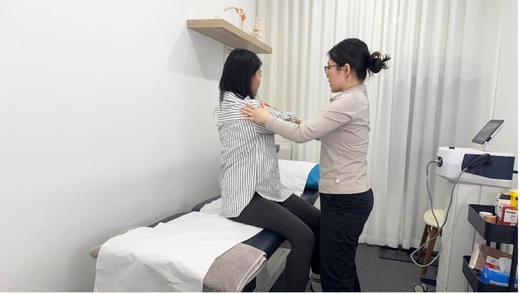 Gentle physiotherapy session with a practitioner assisting a woman post-pregnancy.