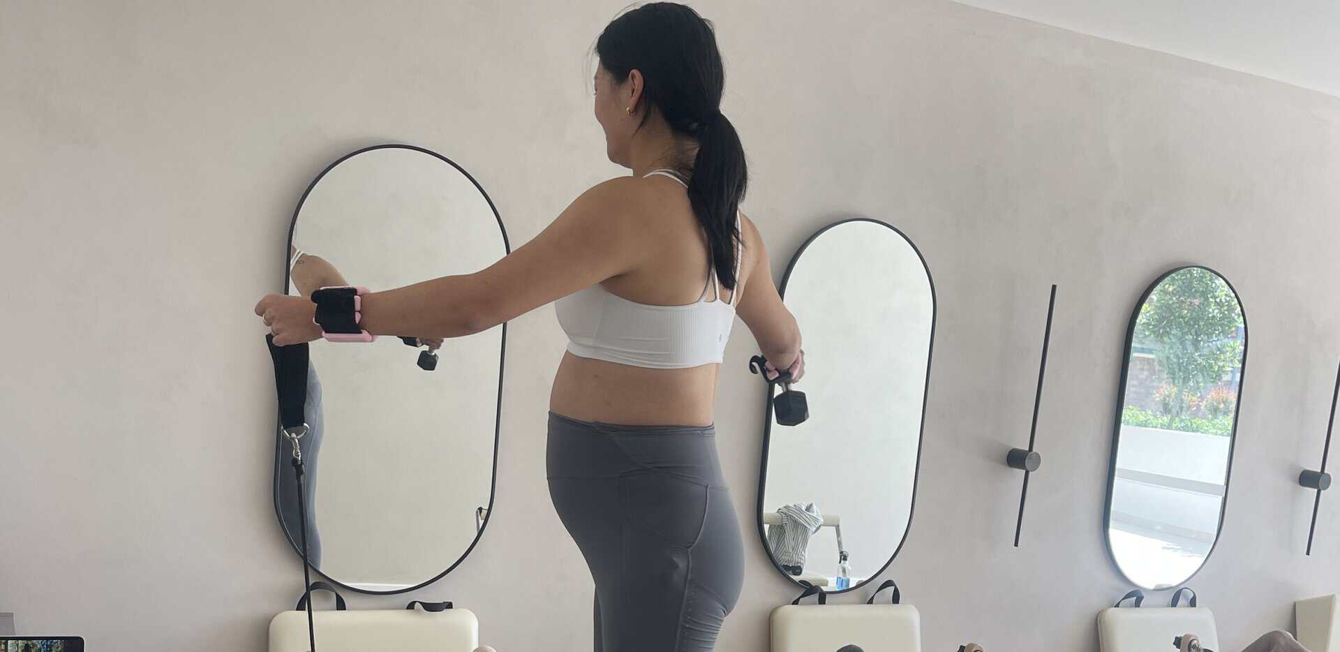 Woman performing abdominal separation exercise with resistance bands in physiotherapy clinic.