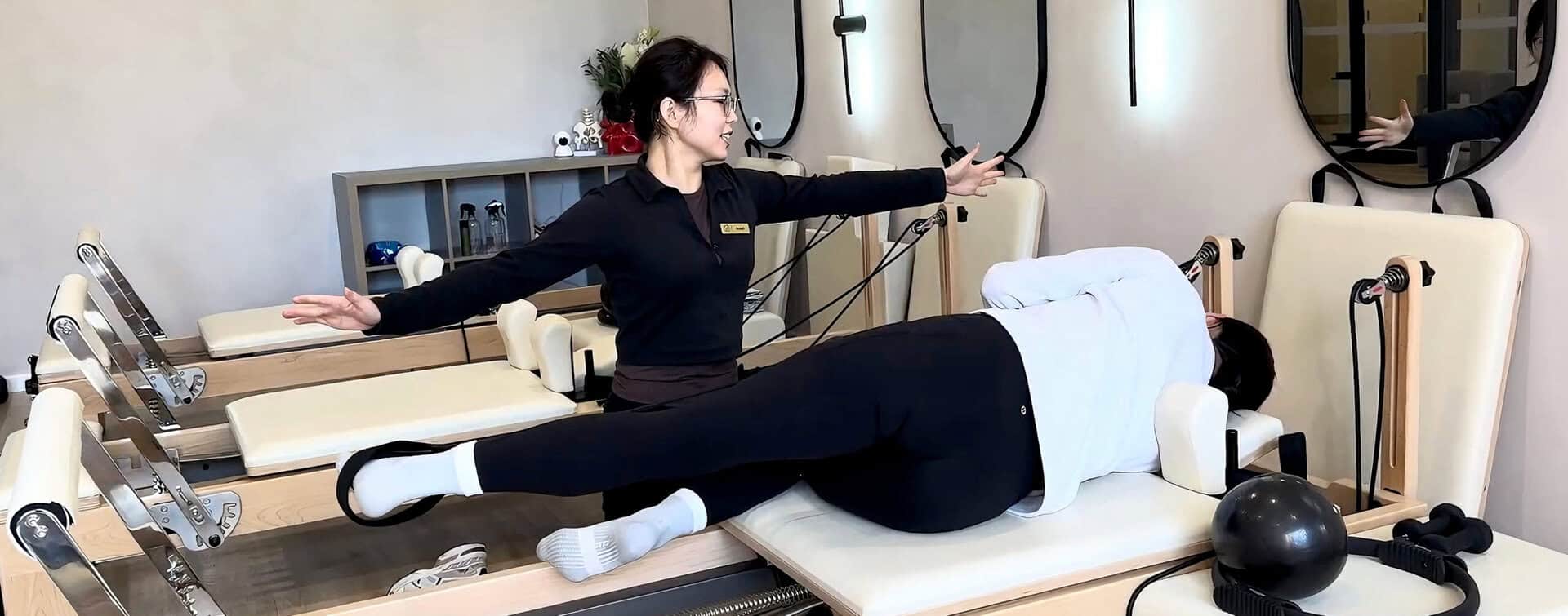 A physiotherapist assisting a patient with leg exercises in a modern clinic setting.
