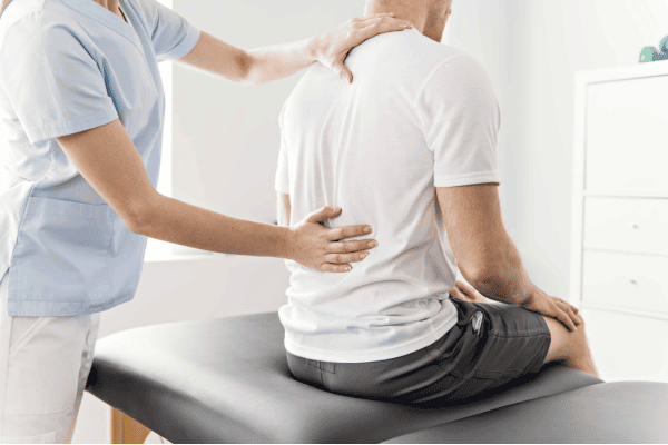 Physiotherapist providing back pain treatment in a clinical setting.